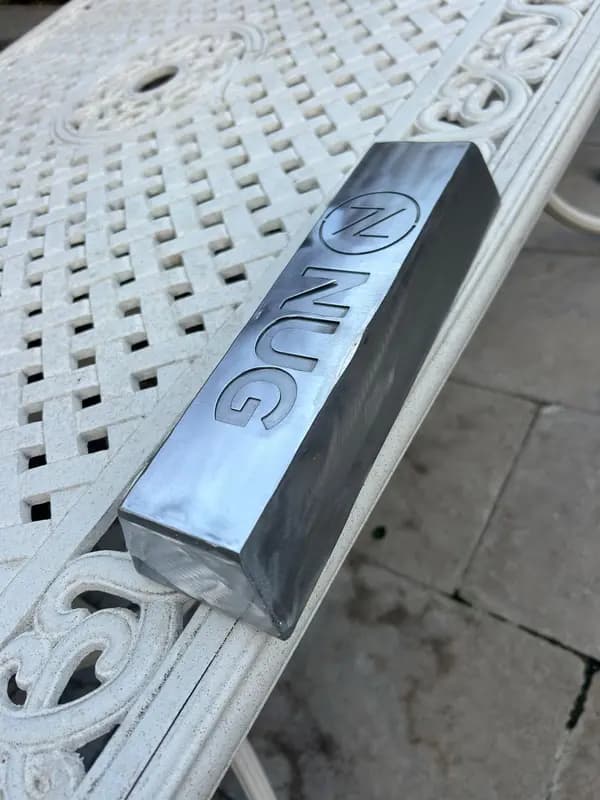 Polished aluminum block with engraved NUG logo